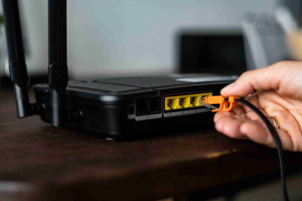 pessoa reiniciando o roteador depois de ver que o wifi não funciona no celular