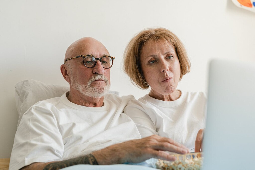 casal assistindo conteúdo pelo computador depois de saber como economizar com TV por assinatura
