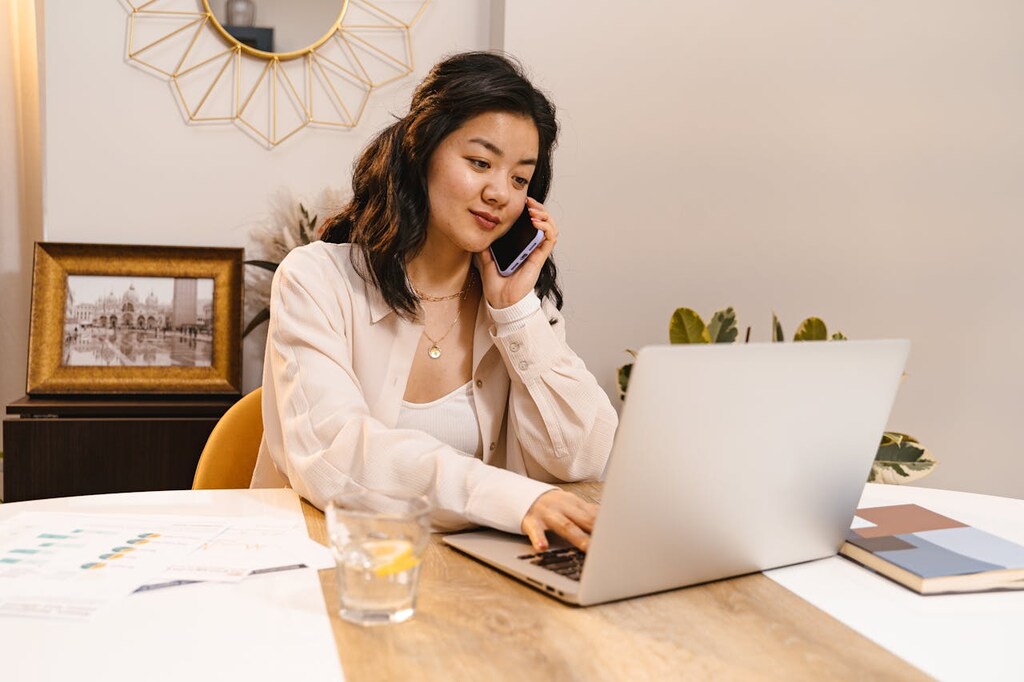 funcionária usando notebook e celular com internet de roteador para empresa