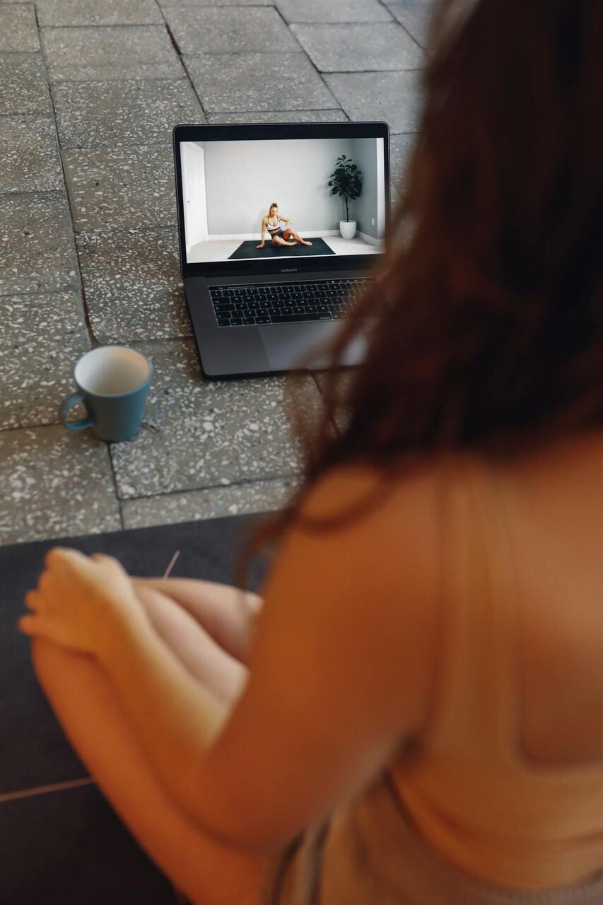 Mulher assistindo vídeo-aula em seu notebook