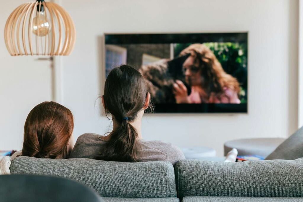 pessoas no sofá assistindo filme na TV depois de saber se HBO Max vale a pena