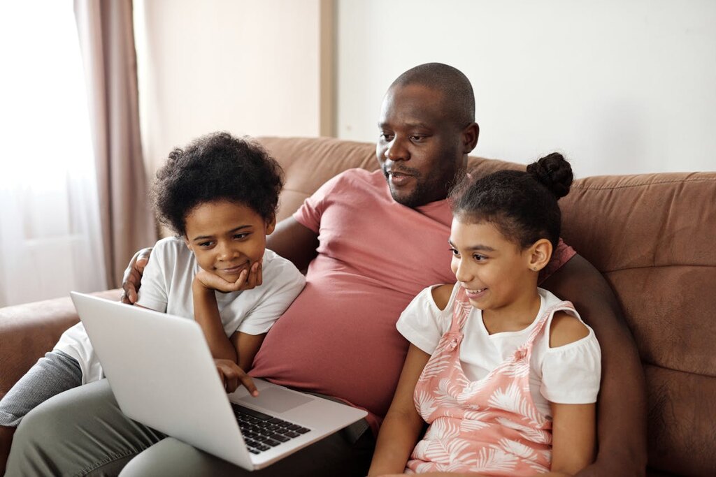 família assistindo conteúdo pelo notebook com a melhor internet para streaming