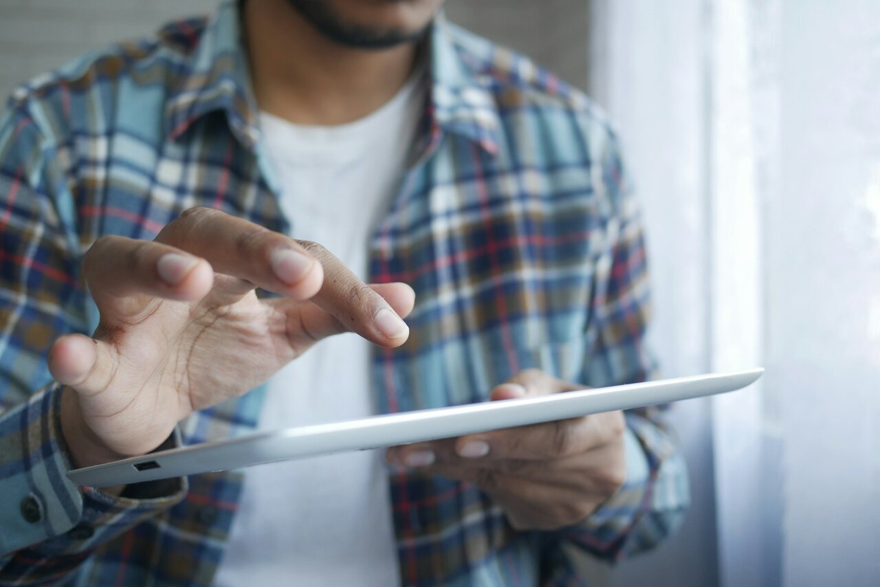 Homem acessando internet pelo tablet