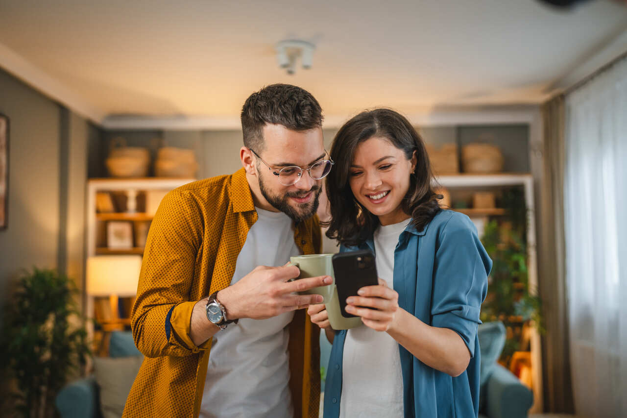 Casal utilizando smartphone para entender a diferença entre Mbps e MBs na velocidade da internet