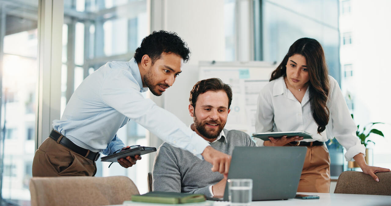 equipe analisando dados em notebook no escrit&oacute;rio utilizando banda larga dedicada para empresas